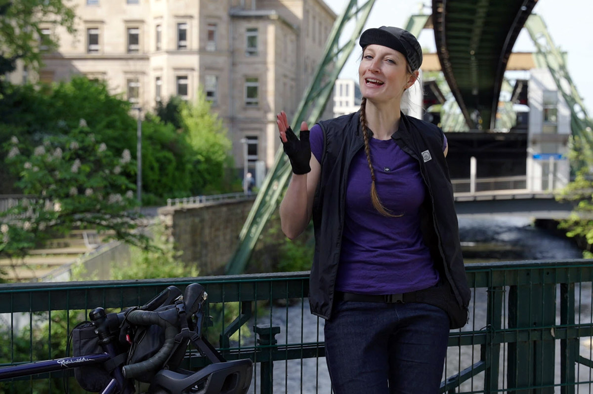 Radfahrerin steht vor Schwebahn in Wuppertal | WestLotto Radtour des Monats
