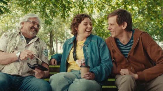Drei Menschen aus NRW sitzen auf einer Parkbank und lachen | WestLotto 